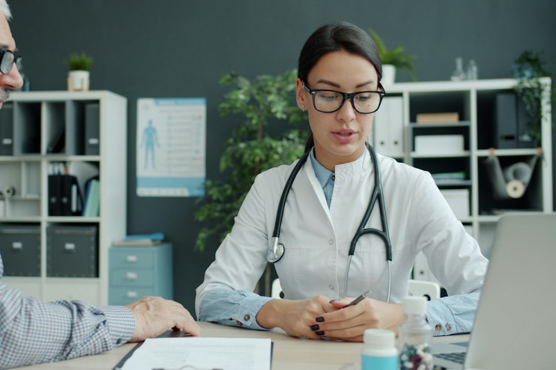 Ärztin im Gespräch mit einem älteren Patienten