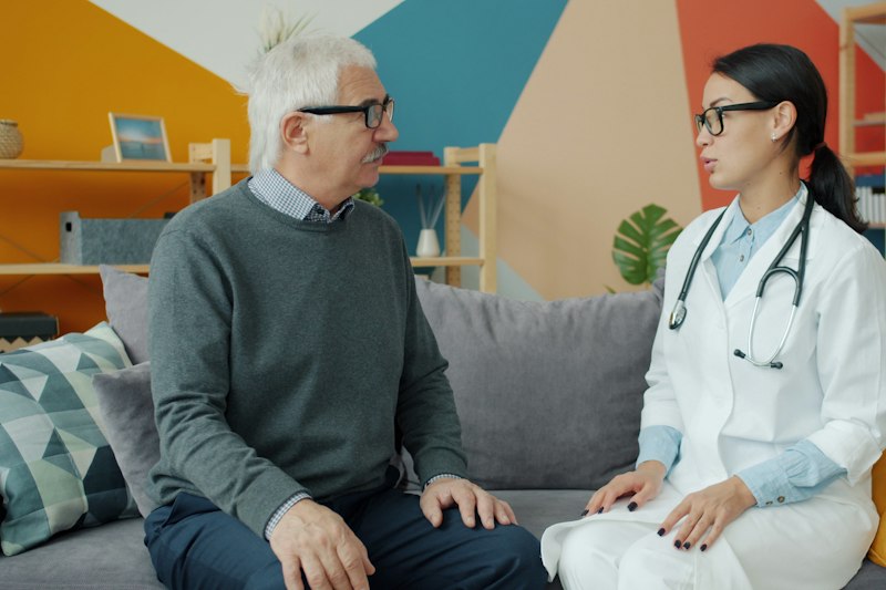 Ärztin besucht einen älteren Patienten zu Hause