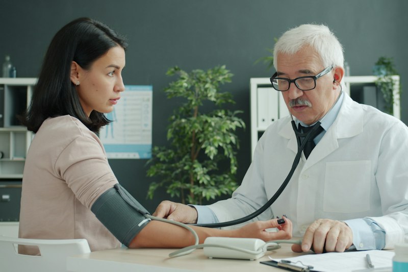 Arzt misst den Blutdruck einer Patientin